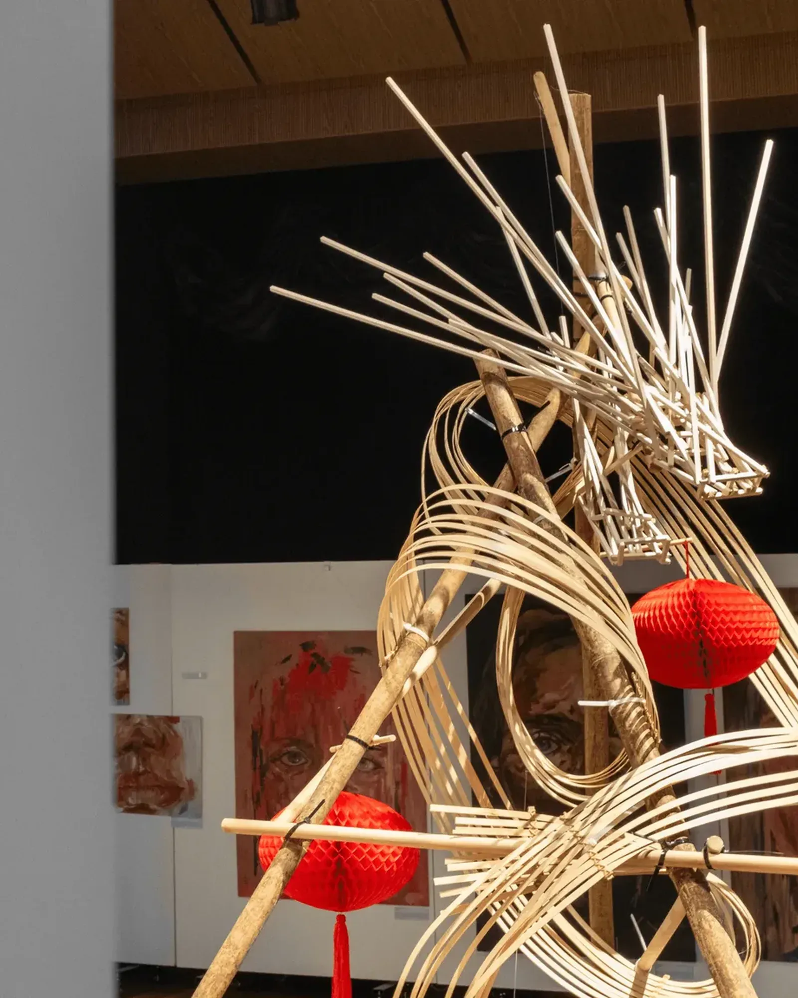 魚躍龍門 Metamorphosis: a bamboo dragon mid-leap through red paper lanterns, in the exhibition hall